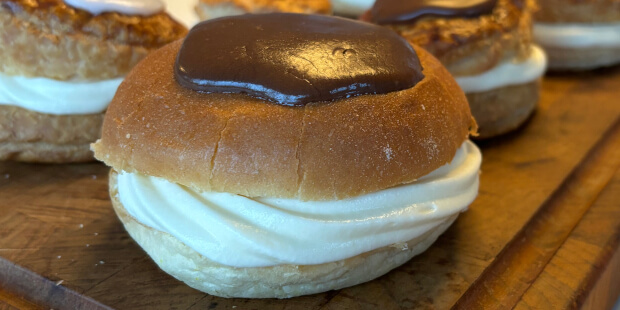 Fastelavnsboller i brioche burgerboller med creme og mørk glasur på toppen.